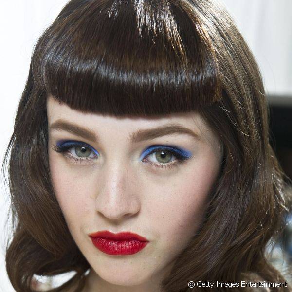 Uma maquiagem que mescla sombra azul com batom avermelhado pode ficar incrível.